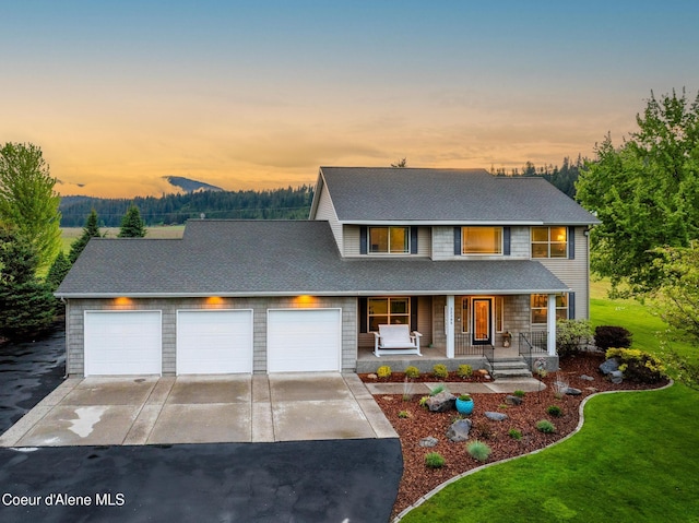 22385 N Ranch View Dr, Rathdrum, ID 83858 - view of front of property with driveway, a porch, an attached garage, a yard, and roof with shingles