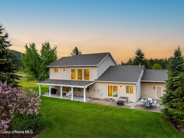 22385 N Ranch View Dr, Rathdrum, ID 83858 - back of house at dusk with a patio area, a lawn, and entry steps