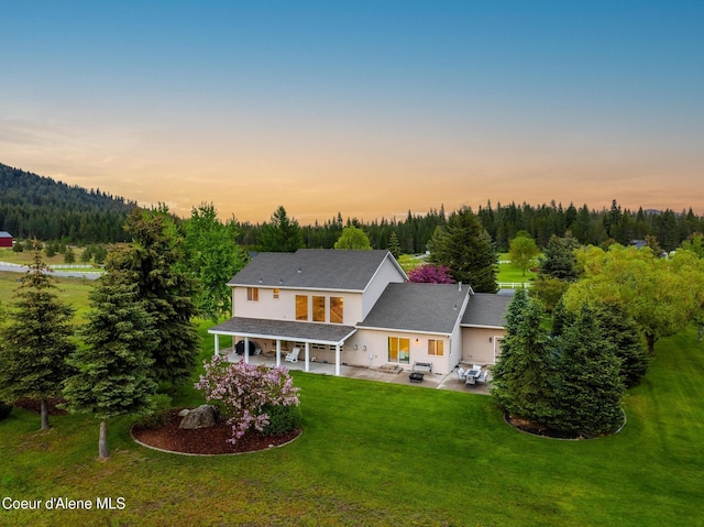 22385 N Ranch View Dr, Rathdrum, ID 83858 - back of house with a lawn, a patio area, and a forest view