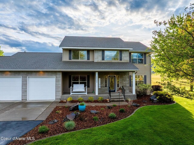 22385 N Ranch View Dr, Rathdrum, ID 83858 - view of front of home featuring driveway, a garage, covered porch, a front yard, and roof with shingles