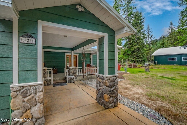 521 Shady Pines Loop, Priest Lake, ID 83856 - entrance to property with stone siding, a patio area, and a lawn