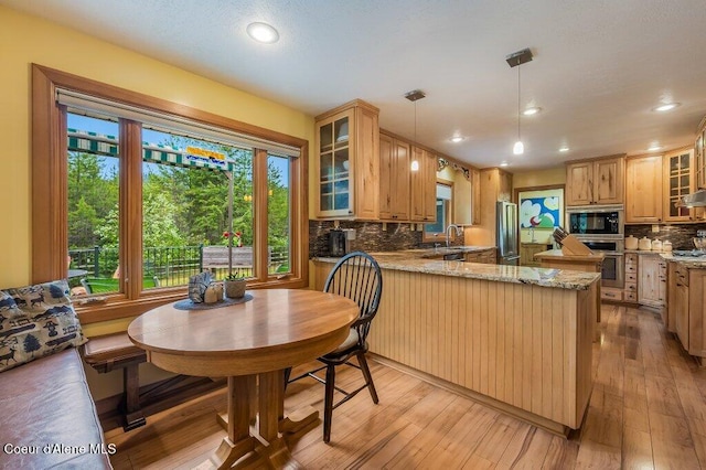 521 Shady Pines Loop, Priest Lake, ID 83856 - kitchen featuring stainless steel oven, fridge, a sink, decorative backsplash, and a peninsula