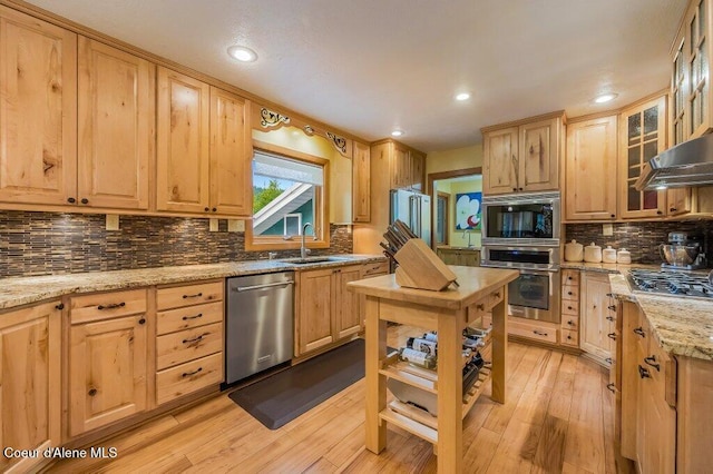 521 Shady Pines Loop, Priest Lake, ID 83856 - kitchen featuring appliances with stainless steel finishes, a sink, light brown cabinetry, tasteful backsplash, and light wood finished floors