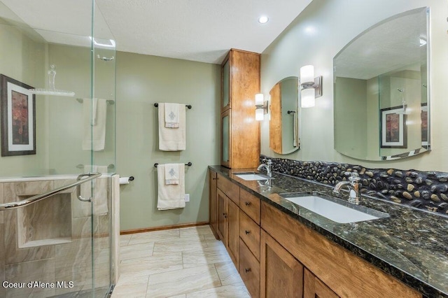 521 Shady Pines Loop, Priest Lake, ID 83856 - bathroom featuring marble finish flooring, a shower stall, double vanity, and baseboards