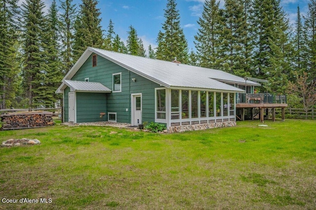 521 Shady Pines Loop, Priest Lake, ID 83856 - back of house featuring metal roof, a lawn, a wooden deck, and a sunroom