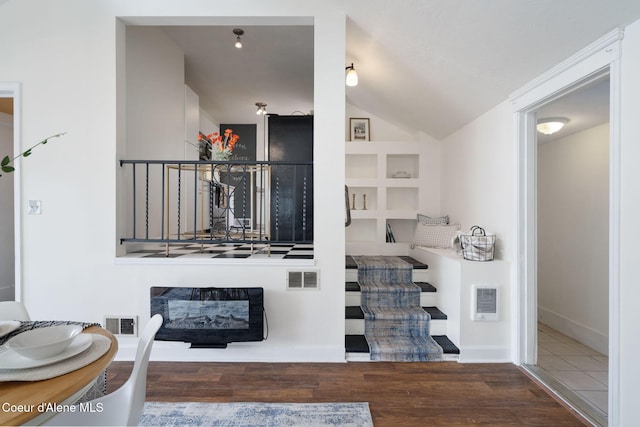 131 Ord Blvd, Nampa, ID 83686 - staircase featuring wood finished floors, built in features, vaulted ceiling, a glass covered fireplace, and baseboards