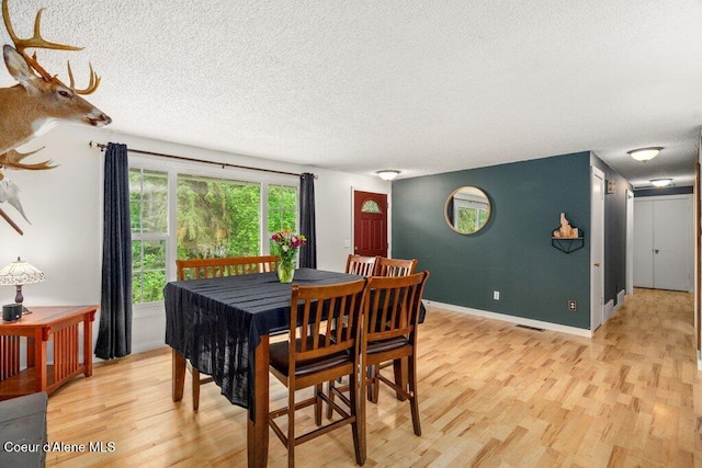 204 Sunrise Dr, Pinehurst, ID 83850 - dining space featuring light wood-style flooring, a textured ceiling, and baseboards