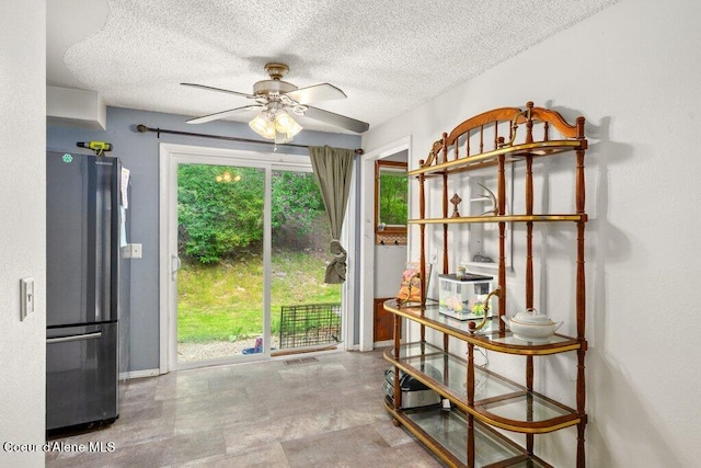 204 Sunrise Dr, Pinehurst, ID 83850 - doorway to outside featuring a ceiling fan, a textured ceiling, and baseboards