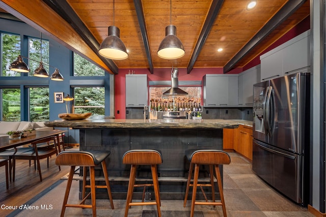 11679 N Avondale Loop, Hayden, ID 83835 - kitchen featuring stainless steel refrigerator with ice dispenser, wall chimney range hood, beamed ceiling, wood ceiling, and plenty of natural light