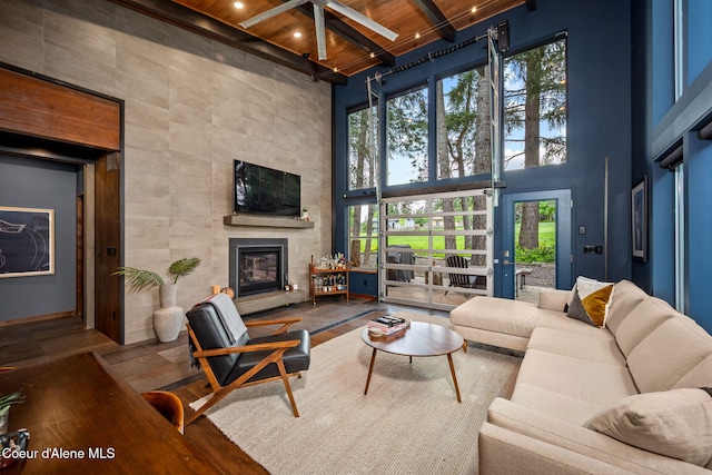 11679 N Avondale Loop, Hayden, ID 83835 - living room with wooden ceiling, a towering ceiling, beam ceiling, a tile fireplace, and plenty of natural light