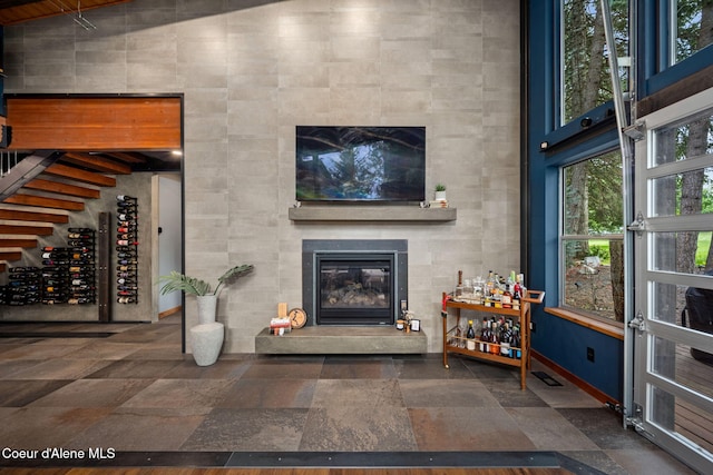 11679 N Avondale Loop, Hayden, ID 83835 - living room with a fireplace, baseboards, stone tile flooring, and a high ceiling