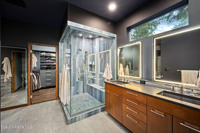 11679 N Avondale Loop, Hayden, ID 83835 - bathroom with a shower stall, double vanity, a walk in closet, and tile patterned floors