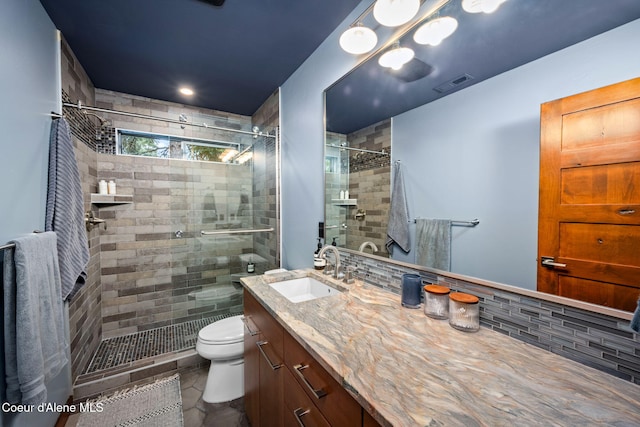11679 N Avondale Loop, Hayden, ID 83835 - bathroom featuring a stall shower, vanity, toilet, and decorative backsplash