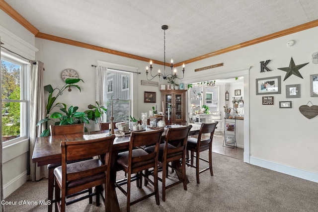 dining room with healthy amount of natural light, a chandelier, crown molding, baseboards, and light colored carpet