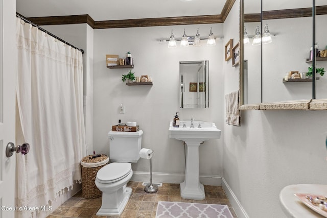 bathroom featuring baseboards, toilet, crown molding, a shower with shower curtain, and a sink