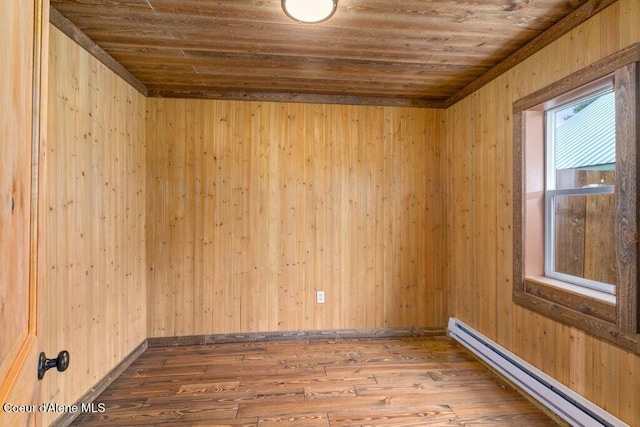 707 Washington Ave, Sandpoint, ID 83864 - spare room featuring a baseboard heating unit, wood ceiling, and wood finished floors