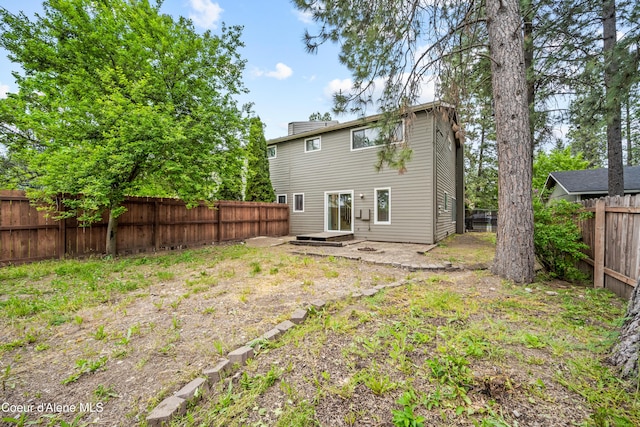 1706 E Thomas Ln, Coeur Dalene, ID 83815 - back of property featuring a fenced backyard and a chimney