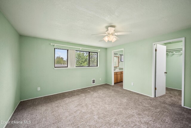 1706 E Thomas Ln, Coeur Dalene, ID 83815 - unfurnished bedroom with carpet flooring, a spacious closet, connected bathroom, ceiling fan, and a closet