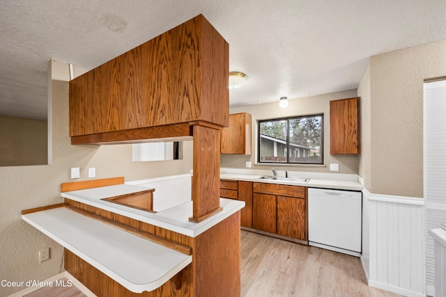 1706 E Thomas Ln, Coeur Dalene, ID 83815 - kitchen with white dishwasher, brown cabinetry, a textured ceiling, a sink, and light countertops