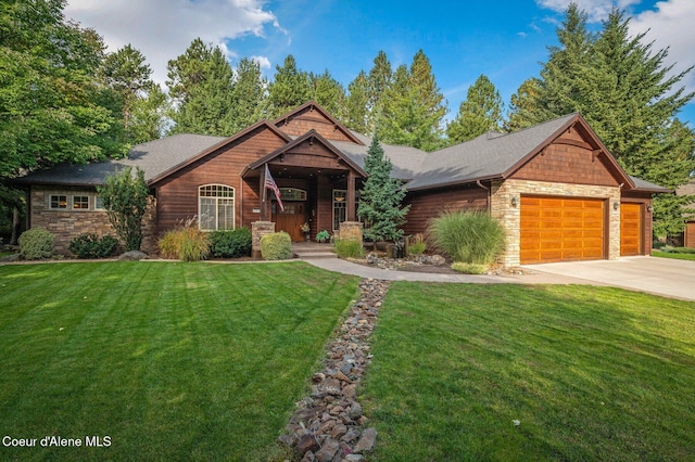 view of front of property with stone siding, an attached garage, a front yard, and concrete driveway