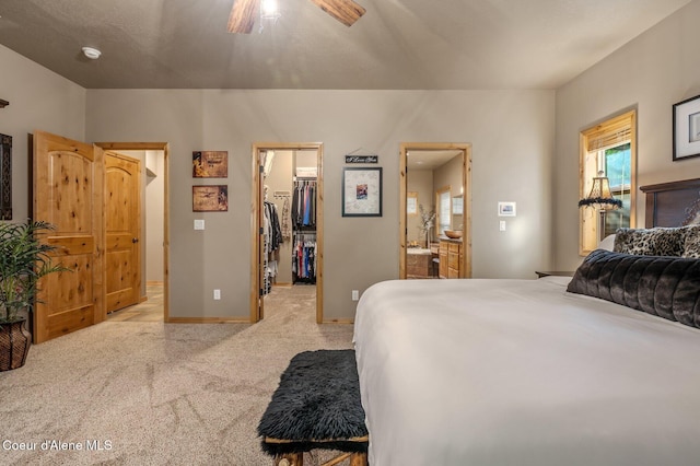 carpeted bedroom with a walk in closet, multiple windows, baseboards, and a closet