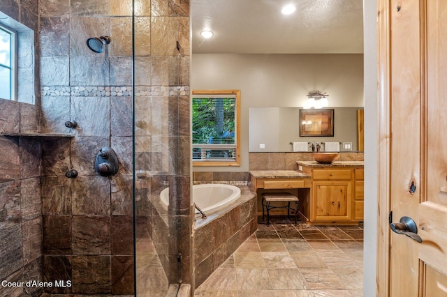 bathroom with walk in shower, a garden tub, healthy amount of natural light, and vanity