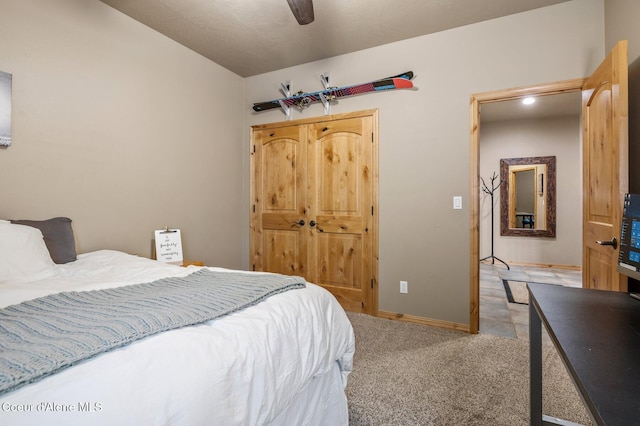 bedroom with light colored carpet, baseboards, ceiling fan, and a closet
