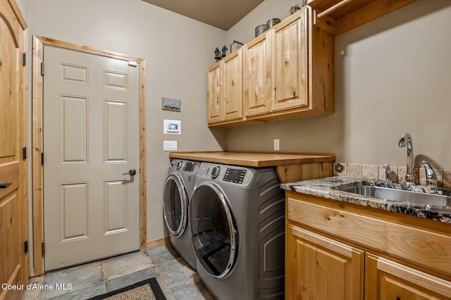 washroom with washing machine and clothes dryer, cabinet space, and light stone finish floors