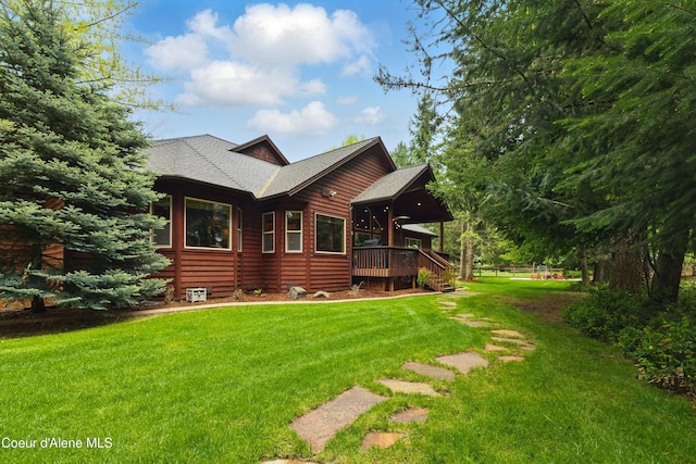 view of front facade featuring a deck, a front yard, and a shingled roof