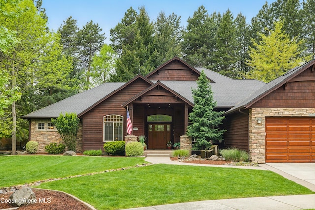 view of front of house with stone siding, an attached garage, a front lawn, and a shingled roof