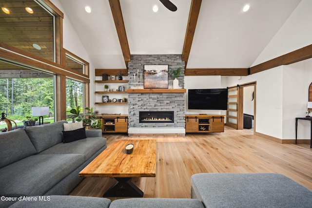 1230 E Amulet Cir, Rathdrum, ID 83858 - living area with high vaulted ceiling, a barn door, light wood finished floors, beamed ceiling, and a fireplace
