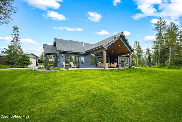 1230 E Amulet Cir, Rathdrum, ID 83858 - rear view of property featuring roof with shingles, a patio area, a lawn, an outdoor hangout area, and an outdoor structure