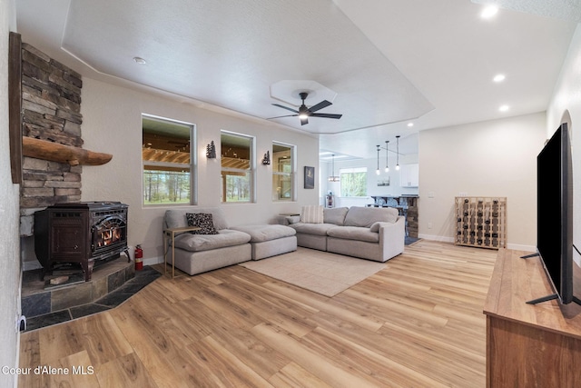 27464 N Timber Ridge Rd, Rathdrum, ID 83858 - living area featuring a wood stove, a ceiling fan, light wood finished floors, baseboards, and recessed lighting