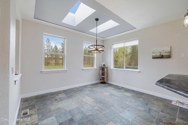 27464 N Timber Ridge Rd, Rathdrum, ID 83858 - unfurnished dining area featuring a skylight, a chandelier, stone finish floors, and baseboards
