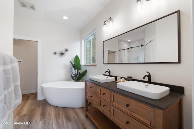 27464 N Timber Ridge Rd, Rathdrum, ID 83858 - full bath with wood finished floors, a stall shower, double vanity, a freestanding tub, and recessed lighting