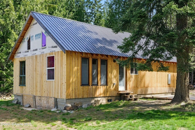 view of side of home with entry steps and metal roof