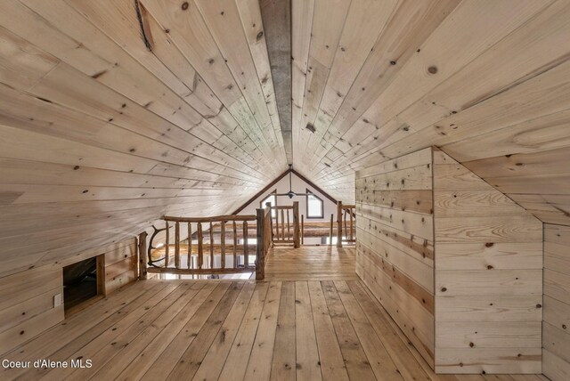 bonus room with wood walls, wooden ceiling, lofted ceiling, and wood-type flooring