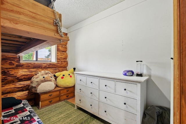 bedroom featuring a textured ceiling and wooden walls