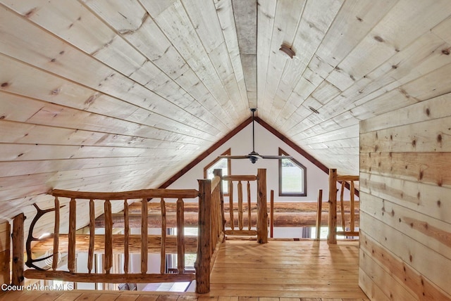 bonus room featuring wooden ceiling, light wood-style flooring, lofted ceiling, ceiling fan, and wood walls