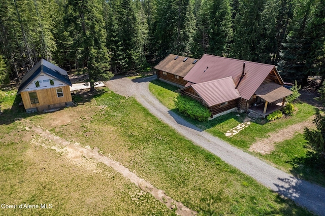aerial view of property and surrounding area featuring a heavily wooded area