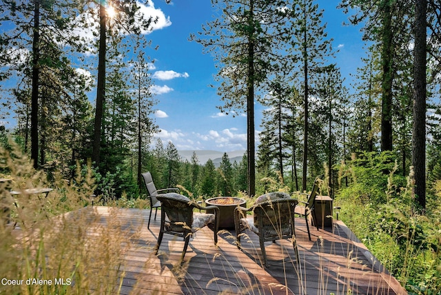 7177 W Heine Rd, Coeur Dalene, ID 83814 - view of patio / terrace featuring a deck with mountain view, an outdoor fire pit, and a wooded view