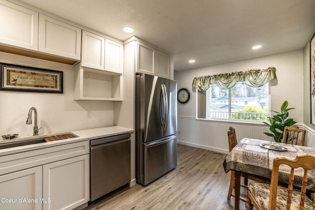 377 E Knotty Pine Ln Unit 2, Coeur Dalene, ID 83815 - kitchen featuring appliances with stainless steel finishes, a sink, wainscoting, light wood-style flooring, and light countertops