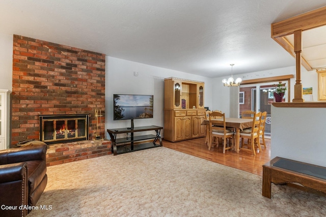 279 S Sequoia Ct, Post Falls, ID 83854 - living area with a chandelier, a brick fireplace, carpet flooring, and wood finished floors