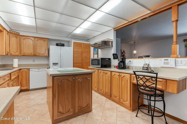 279 S Sequoia Ct, Post Falls, ID 83854 - kitchen featuring white appliances, a kitchen island, a peninsula, a sink, and light countertops
