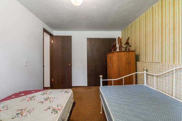 279 S Sequoia Ct, Post Falls, ID 83854 - bedroom with wallpapered walls, carpet, a closet, and a textured ceiling
