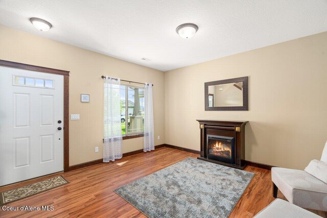 1761 W Pyrenees Loop, Coeur Dalene, ID 83815 - foyer featuring baseboards, wood finished floors, and a glass covered fireplace