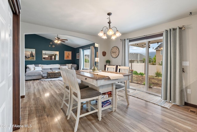 6595 W Covenant St, Rathdrum, ID 83858 - dining space with arched walkways, wood finished floors, vaulted ceiling, ceiling fan, and a chandelier