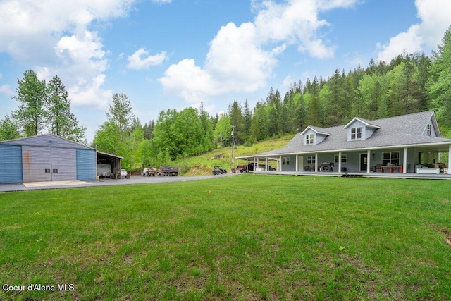 911 French Gulch Rd, Kingston, ID 83839 - view of grassy yard featuring a porch, a carport, a wooded view, and an outdoor structure