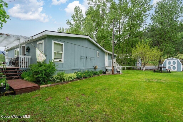 911 French Gulch Rd, Kingston, ID 83839 - view of property exterior featuring a deck, a storage unit, an outdoor structure, and a yard