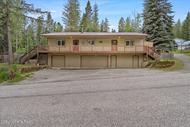 1072 Upland Dr, Sandpoint, ID 83864 - view of front of property with stairway, an attached garage, driveway, and metal roof